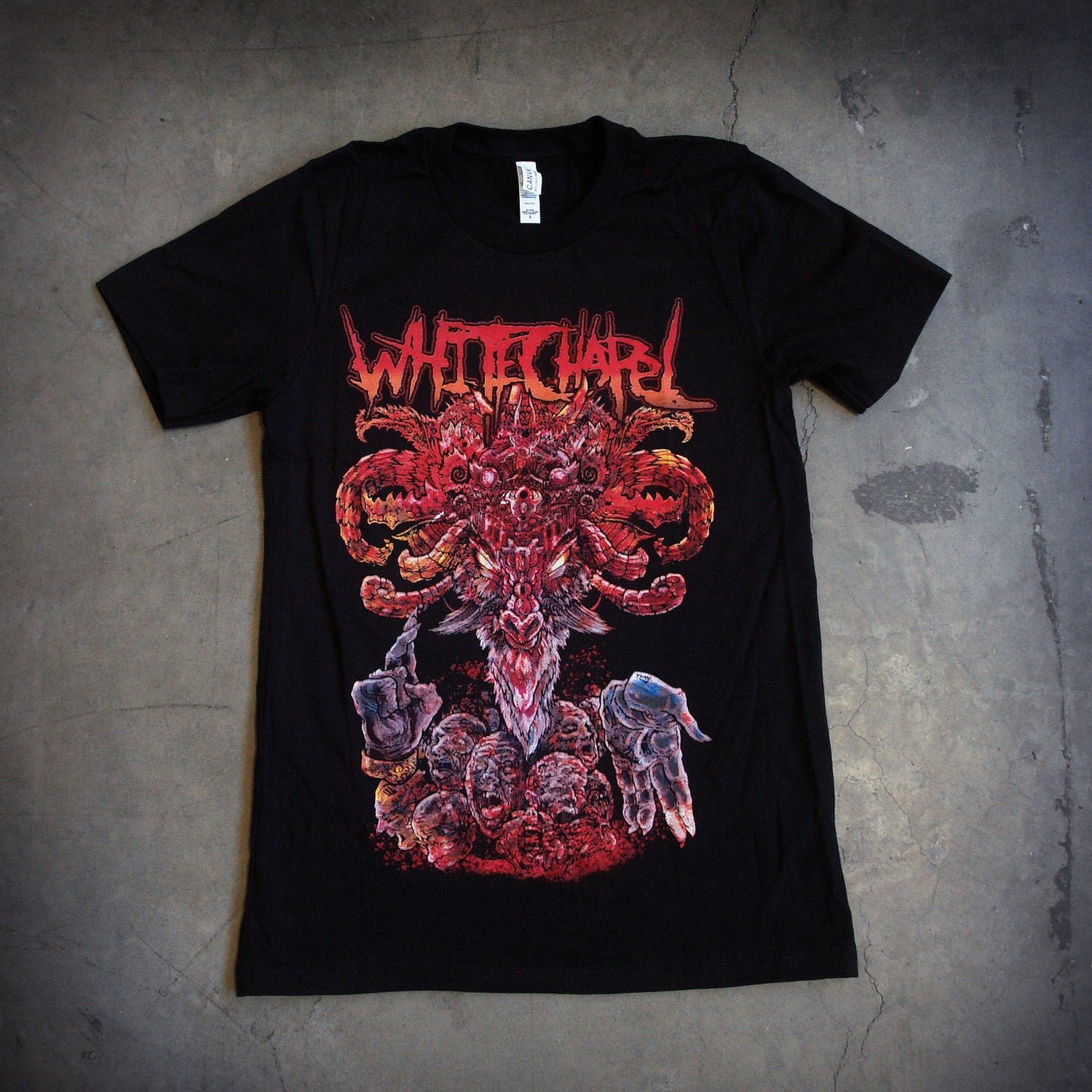 image of a black tee shirt. tee has full color body print of a demon medusa like head. at the top says whitechapel