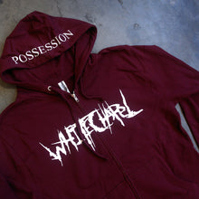 Load image into Gallery viewer, image of a maroon zip up hoodie laid flat on a concrete floor. front of the hoodie is on the left and has a white print across the chest that says whitechapel. the hood is in the middle and shows a white print across the brim that says possession.
