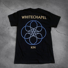 Load image into Gallery viewer, image of the back of a black tee shirt on a cracked concrete background. The back reads &quot;whitechapel&quot; across the shoulders in tan text. Below this is an abstract thin lined pattern in white and blue. It looks like a circle with lines and stars in the center. Below this in tan text reads &quot;kin&quot;.

