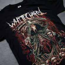 Load image into Gallery viewer, up close Image of the front of a black tshirt against a grey concrete background. the shirt features a red, white, black, and bluish gray graphic of a an animal skull with a third eye holding a scythe and wearing a cloak. Its ribs are showing. There are skull heads all around the monster. There is a red background behind the graphic.
