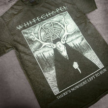 Load image into Gallery viewer, close up, angled image of a oil washed black tee shirt laid on a concrete floor. tee has full body print in white of a deer wearing a cloak outside in the woods. at the top says whitechapel and the bottom says there&#39;s nowhere left to run
