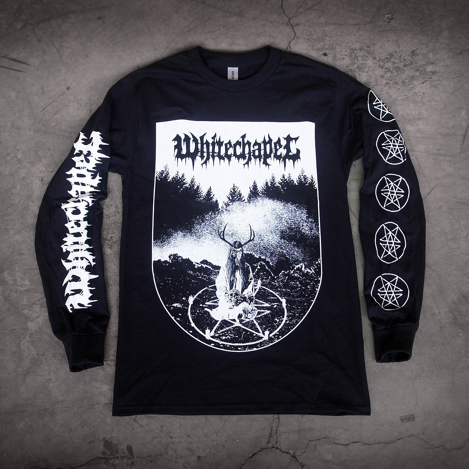 image of a black long sleeve tee shirt laid on a concrete floor. front of shirt has full body print in white that says whitechapel at the top over a scene of a ritual in the woods with a pentagram. left sleeve says whitechapel and right sleeve has five pentagrams