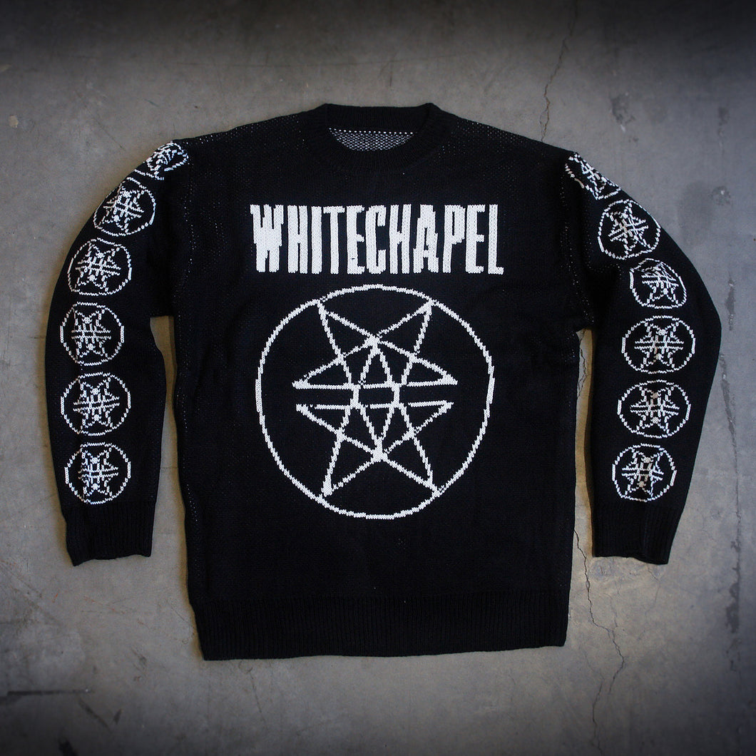 image of a custom black woven sweater laid flat on a concrete floor. sweater has white thread. the front has a full body double pentagram in the center and says whitechapel at the top across the chest. each sleeve has six double pentagrams 