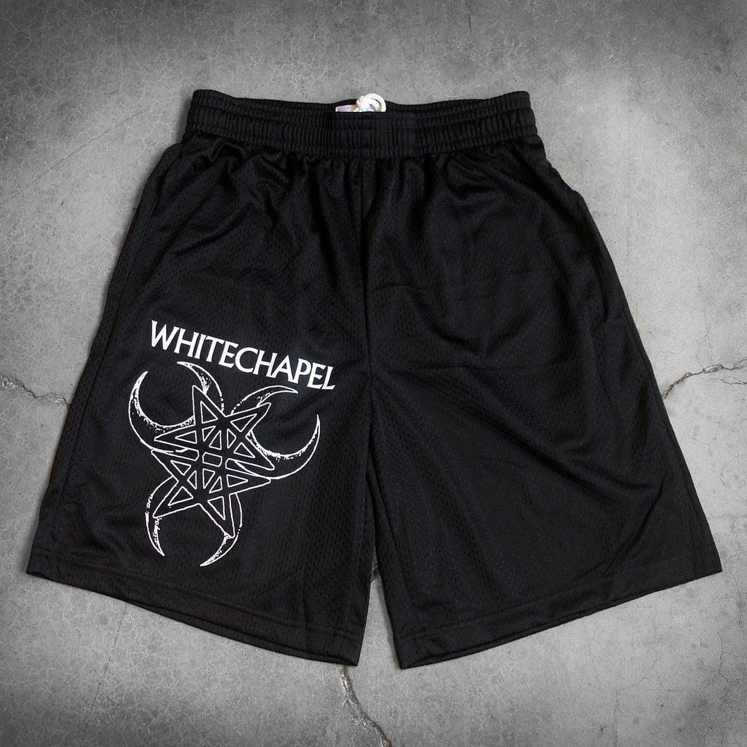 Image of black athletic shorts against a grey concrete background. The right bottom of the leg of the shorts says 
