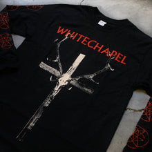 Load image into Gallery viewer, close up Image of a black longsleeve against a grey concrete background. Across the chest in red text reads &quot;whitechapel&quot;. Below that is a graphic of a white crosswith antlers on it, and an animal skull in the center of the cross. The sleeves feature a graphic of a red outline circle with no fill, with two red stars mirroring each other on the inside of it. This appears on the sleeves repeatedly from the top to the bottom of them.
