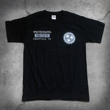 Load image into Gallery viewer, image of the front of a black tee shirt on a concrete background. the front of the tshirt has a grey sawblade with three white stars in the center of the sawblade on the left chest. The right chest says whitechapel, mmxiv, knoxville tn in a grey white text.
