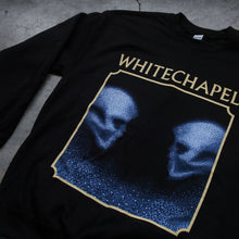 Load image into Gallery viewer, close up Image of a black crewneck against a grey concrete background. The crewneck features the heads of two skulls, looking at one another. This is in blue. They are made up of blue and black static- and the static is beneath them too. This is outlined in an off white square. Above the square in an off white text reads &quot;whitechapel&quot;.
