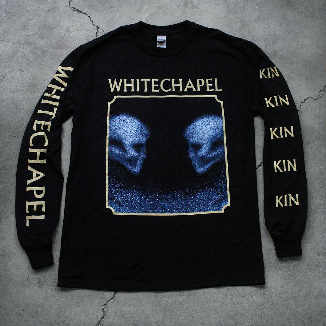 Image of a black longsleeve against a grey concrete background. The crewneck features the heads of two skulls, looking at one another. This is in blue. They are made up of blue and black static- and the static is beneath them too. This is outlined in a white square. Above the square in white text reads 