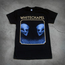 Load image into Gallery viewer, image of the front of a black tee shirt on a cracked concrete background. The front shows two skulls looking at one another- made up of blue and black static. The static is beneath them too. This is outlined in a tan square. Above the square in tan text reads &quot;whitechapel&quot;. 
