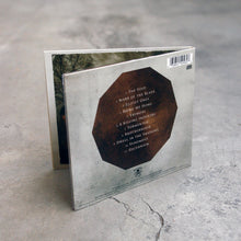 Load image into Gallery viewer, image of the back of a CD on a concrete floor. The back side shows the tracklist
