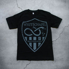 Load image into Gallery viewer,  Image of a black tshirt against a grey concrete background. There is a graphic of a grey badge on the shirt, inside this badge in grey text reads &quot;whitechapel&quot;. Below this is a graphic of a snake with its tongue out. There are three small stars next to the snake. Below this are grey stripes, and in between the stripes in the middle reads &quot;brotherhood&quot;.
