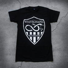 Load image into Gallery viewer, Image of a black tshirt against a grey concrete background. There is a graphic of a white badge on the shirt, inside this badge in white text reads &quot;whitechapel&quot;. Below this is a graphic of a snake with its tongue out. There are three small stars next to the snake. Below this are white stripes, and in between the stripes in the middle reads &quot;brotherhood&quot;.
